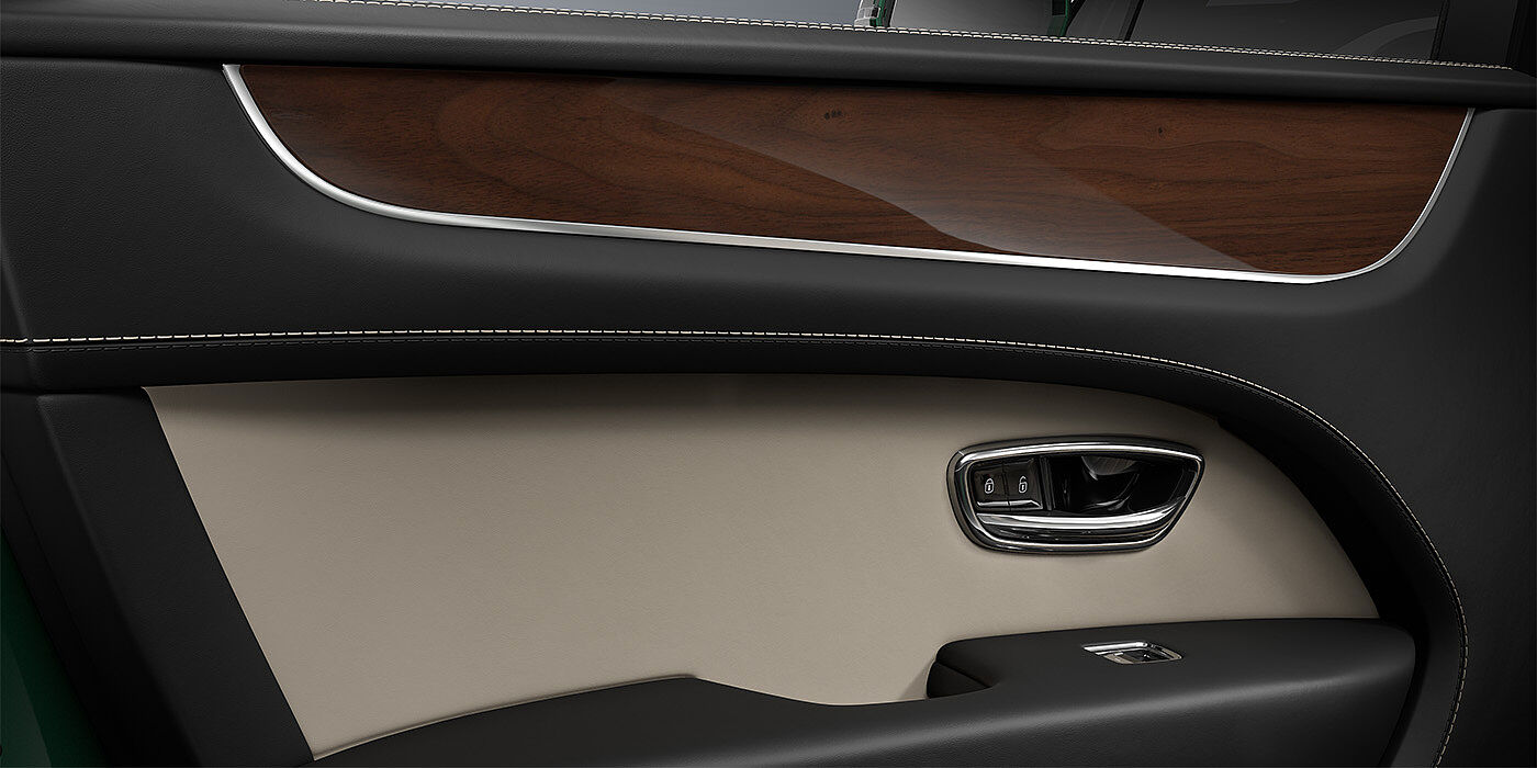 Bentley Hannover Bentley Bentayga SUV door interior detail in Portland and Beluga black hides with Crown Cut Walnut veneer