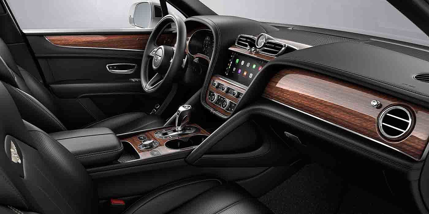 Bentley Hannover Bentley Bentayga EWB interior with a Crown Cut Walnut veneer, view from the passenger seat over looking the driver's seat.