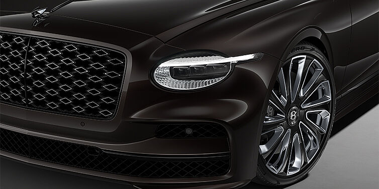 Bentley Hannover New Bentley Flying Spur Mulliner sedan head lamp against Havana brown paint with  22" Mulliner Black Painted & Polished wheel