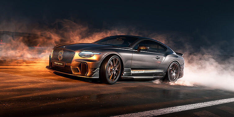 Bentley Hannover Bentley Supersports front three quarter in "Nightfall" Design theme with Anthracite paint, Camel accents and Camel and Beluga black striping standing on mist covered concrete