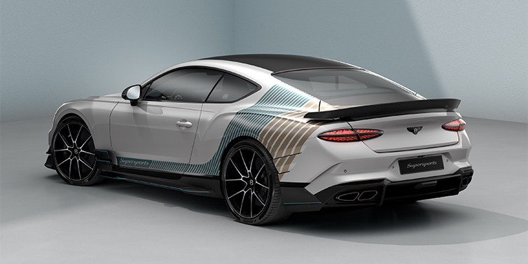 Bentley Hannover Bentley Supersports rear three quarter in "Snowstorm" Design theme with Snow Quartz paint and Topaz blue and Camel brown paint stripes across the rear haunch.