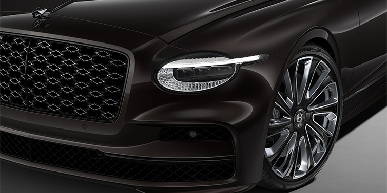 Bentley Hannover New Bentley Flying Spur Mulliner sedan head lamp against Havana brown paint with  22" Mulliner Black Painted & Polished wheel